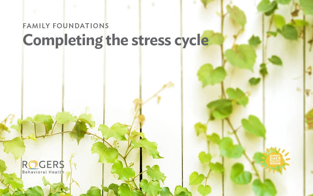 The image features a light-colored wooden wall overgrown with green ivy vines. The vines are scattered across the surface, with some leaves appearing in clusters and others more spaced out. In the upper left corner, text is written in large, bold letters.: FAMILY FOUNDATIONS Completing the stress cycle