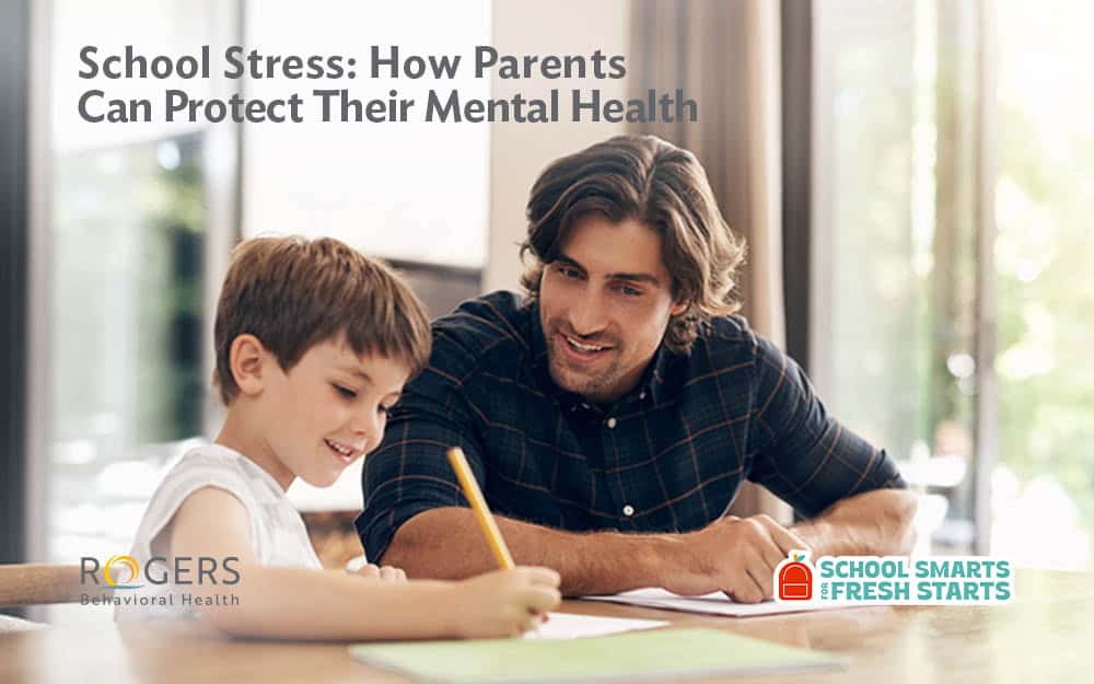 The image shows a bright and cozy interior space where a man and a young boy are seated at a table engaged in an activity. The man, with wavy dark hair and a plaid shirt, smiles while leaning over to assist the boy, who is holding a pencil and writing on a piece of paper. Large windows in the background allow natural light to fill the room, creating a warm atmosphere. On the upper left side of the image, there is text : How Parents Can Protect Their Mental Health and a logo: School Smarts for Fresh Starts