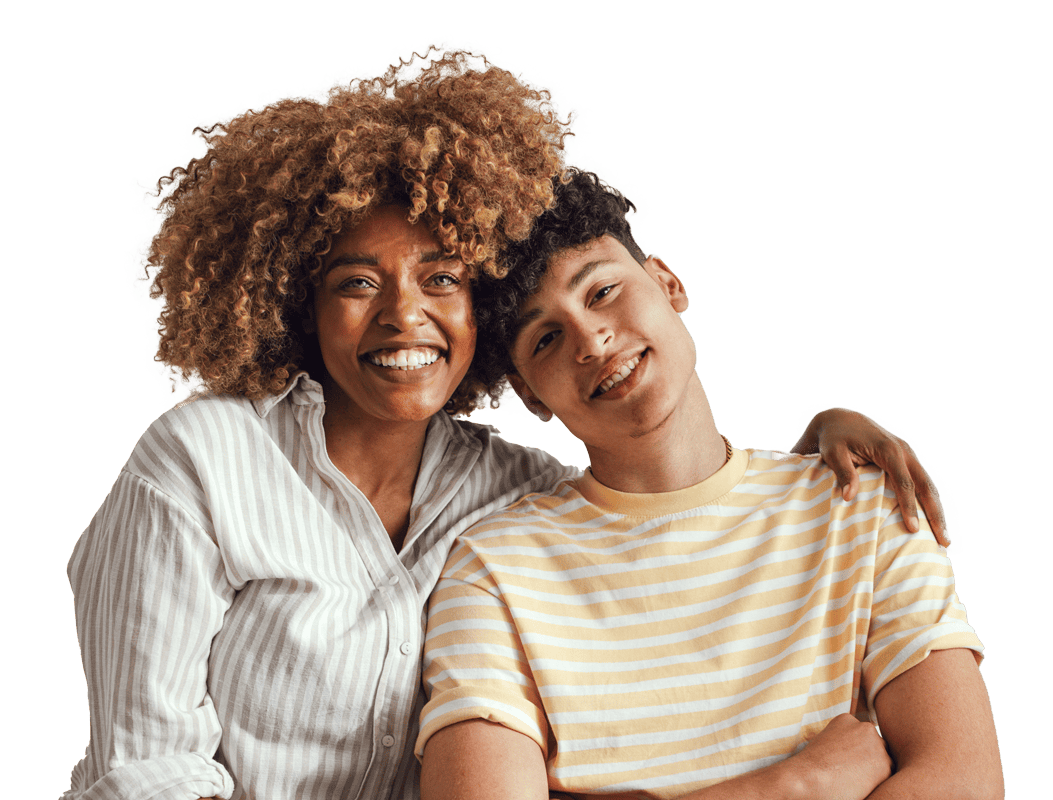 A mother and her teenage son sitting close together, smiling, with one having curly hair and wearing a striped shirt, the other wearing a yellow striped T-shirt.